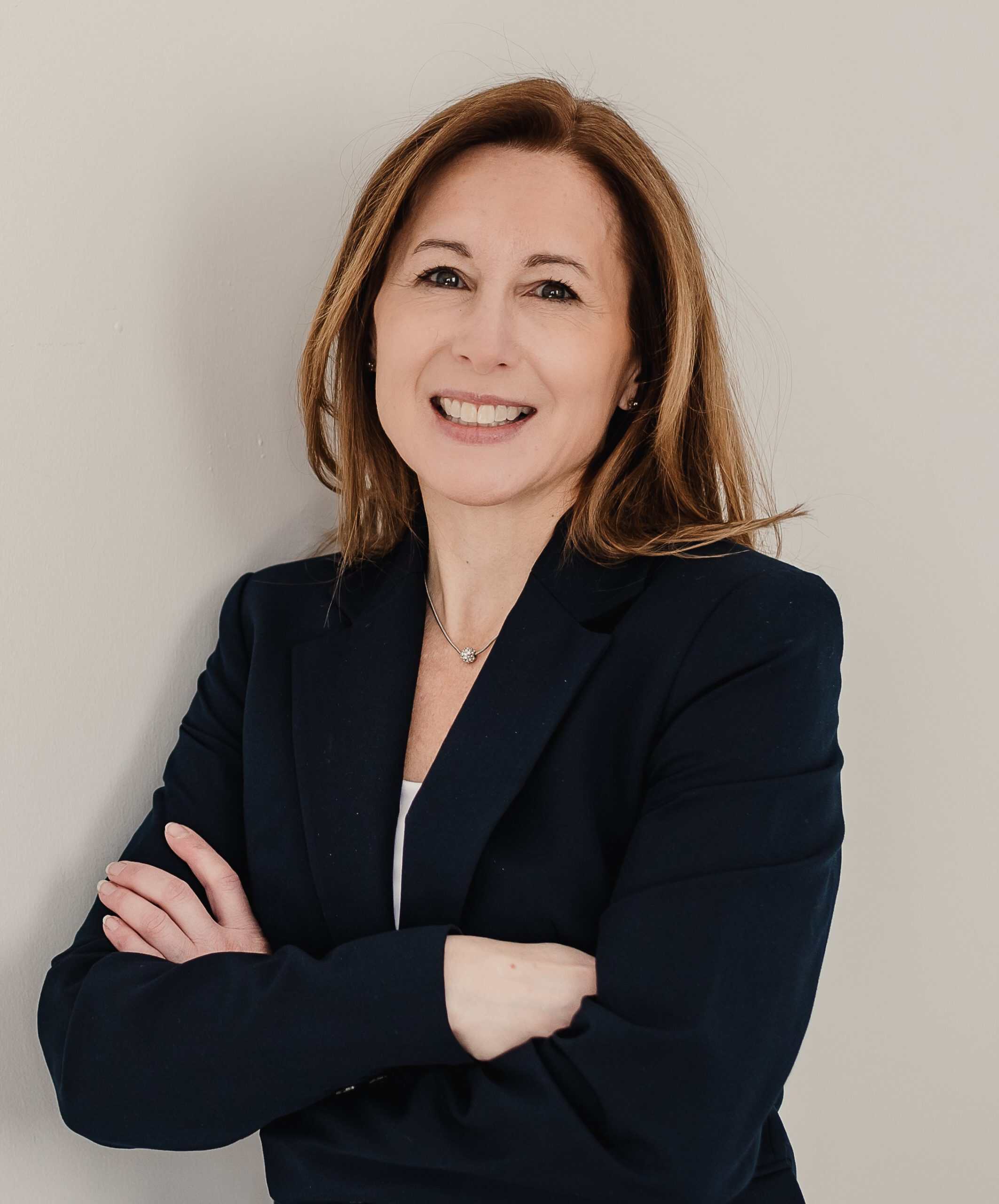 Confident woman in business attire with crossed arms for Hammer Appraisals.